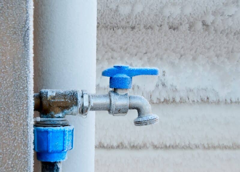 a water hose spout covered in frost and frozen outside a dallas home