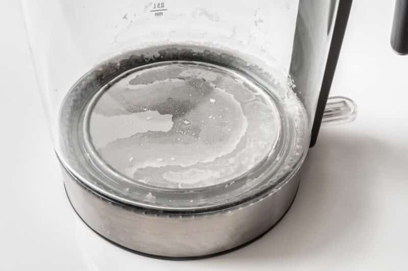 Limescale buildup at the bottom of a clear, electric kettle