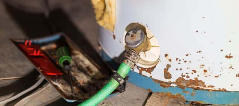 close up of tanked water heater hose valve that has rust building up towards the bottom