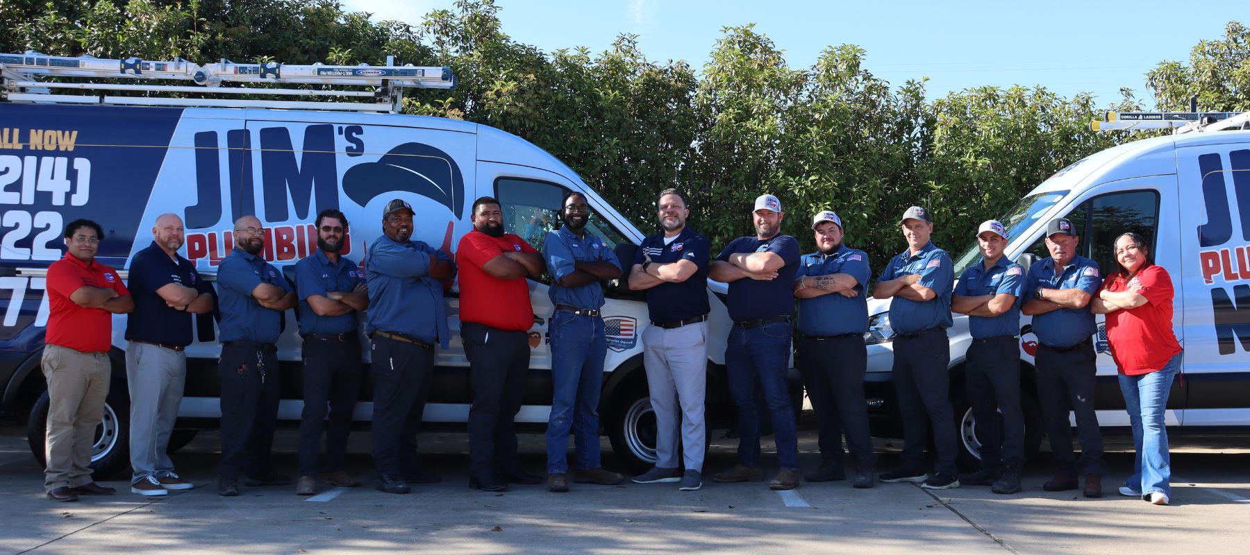 Jim's Plumbing Now team standing in front of branded vans, posing with arms crossed