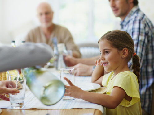 parent pouring water from pitcher